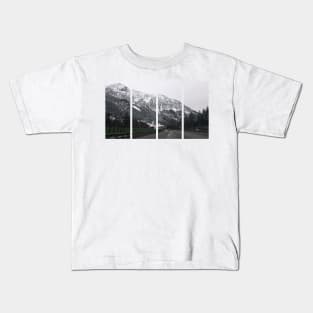 A shot on the move from the windshield of an electric car with a snow-covered alps mountain in front of it in a cold cloudy winter day. POV first person view shot on a mountain highway. Kids T-Shirt